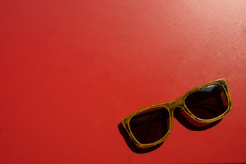 sunglasses on red background in Summer morning