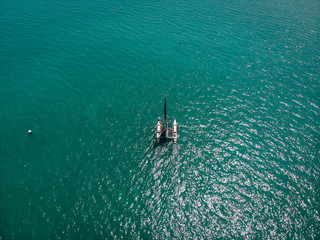 Bird eye view of the small sailing kayak; black sails in the wind. Regatta concept.