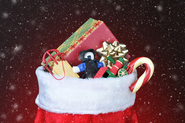 Christmas Stocking filled with toys - Light to dark red background with snow effect.