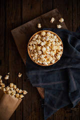 Delicious popcorn with caramel on wooden background..