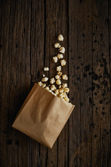 Delicious popcorn with caramel on wooden background..