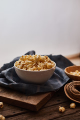Delicious popcorn with caramel on wooden background..