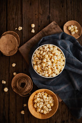 Delicious popcorn with caramel on wooden background..