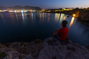 Fototapeta premium the guy on the edge of the cliff looks into the distance