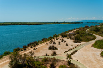 above view of river ebro delta end with cycling track on clear sunny summer day with blue sky