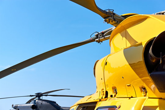 Yellow and black helicopter. Close up of helicopter main rotor blades against a blue sky with copy space.