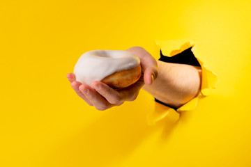 Hand offering a white donut