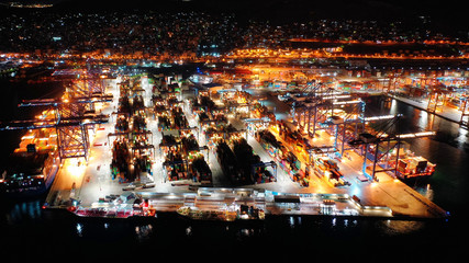 Aerial night shot of illuminated industrial cargo truck size container terminal in Asia port