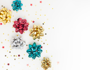 Christmas or New Year composition with colored sparkling ribbon decorations on white background. Flat lay, copy space