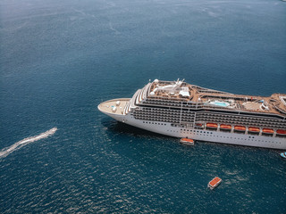 A large cruise liner viewed from the drone in the blue sea, deck, details; cruise vessel concept.