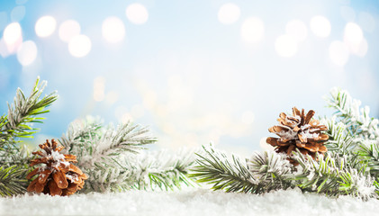 Fototapeta na wymiar Christmas fir tree branches with pine cones on blurred blue .background. Christmas and Winter concept..