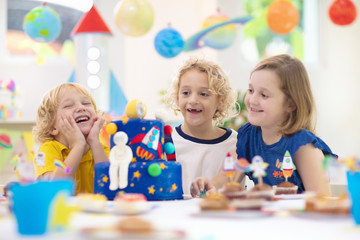 Kids space theme birthday party with cake.