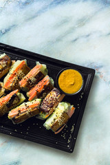 healthy vegan spring rice paper rolls with fried tofu cheese and fresh vegetables and almond sauce