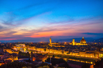 Top aerial panoramic evening view of Florence city with Duomo Santa Maria del Fiore cathedral, Arno river, Ponte Vecchio bridge and Palazzo Vecchio palace at night dusk, city lights, Tuscany, Italy