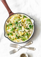 Fresh papardelle with chicken, green peas white bolognese sauce and fennel in pan on light background, top view