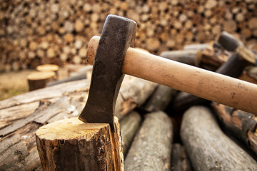 Ax stuck in the stump. wooden stump in the forest. Deforestation man. Felled tree. Woodcutter's ax on the stump.