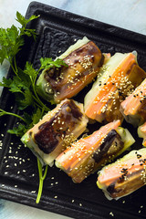 healthy vegan spring rice paper rolls with fried tofu cheese and fresh vegetables and almond sauce