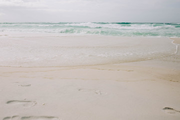 Beach with light blue water and white sand