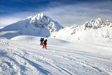Two children are skiing on mountain piste in French Alps