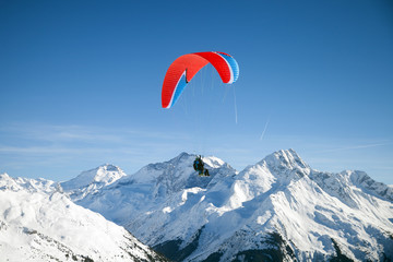 Two skiers with paraglider is flying above mountains - 298961254