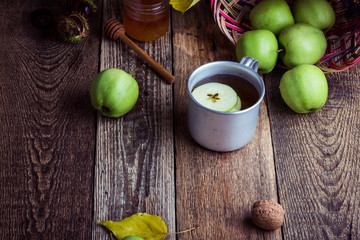 Rural mug with apple hot drink and fresh green apples