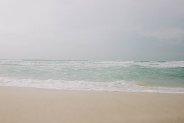 Fototapeta na wymiar Beach with light blue water and white sand