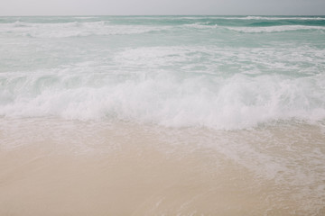 Beach with light blue water and white sand
