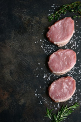 Slices of raw organic pork meat with ingredient for making. Top view with copy space.