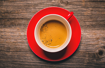 Cup of aromatic black coffee on a wooden background.