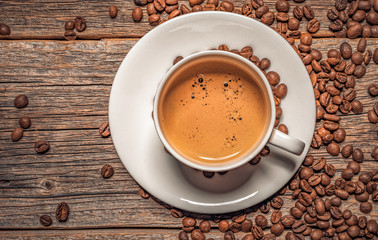 Cup of aromatic black coffee on a wooden background.