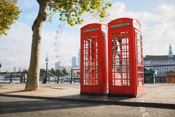 Raamstickers Two London Telephone Boxes on an Empty Street by the River Thames © Christian