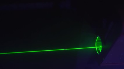 Glowing green laser beams at nightclub, concert or music festival. Night party atmosphere.