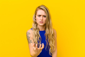 young blonde woman looking angry, annoyed and frustrated screaming wtf or what‚Äôs wrong with...
