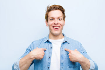 young red head man feeling happy, surprised and proud, pointing to self with an excited, amazed...