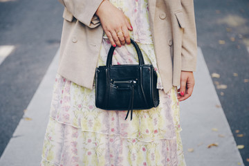 street style detail of a fashionable woman wearing an oversized blazer, vintage floral dress and a...