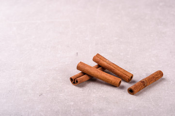 cinnamon in tubes on a gray background