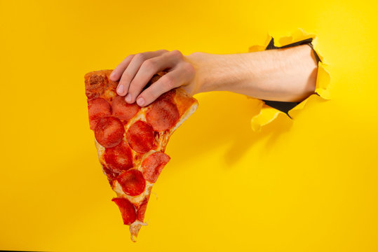 Hand holding a pizza