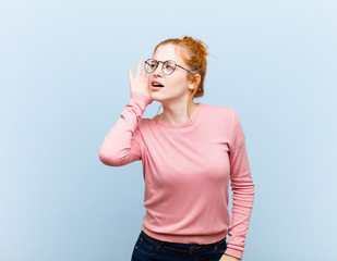young red head pretty woman looking serious and curious, listening, trying to hear a secret...