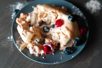 Pavlova Cake with Berries. Meringue Dessert with whipped cream and fresh raspberry and blueberry.