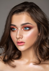 Beautiful young model with colorful trendy smoky eyes, bright blue eyes and natural hairdo