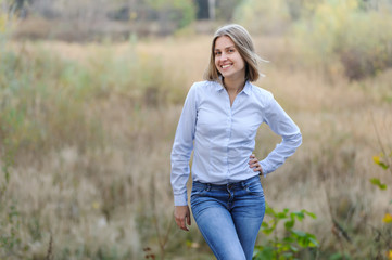 Obraz premium Casually dressed smiling business woman on a nature background