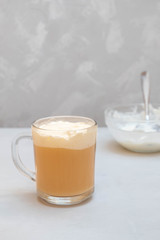 Cup of cheese tea on grey background. Black tea with cream cheese foam. Milk tea
