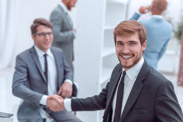 happy entrepreneur shaking hands with his business partner
