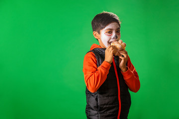 NIÑO COMIENDO PAN DE MUERTO