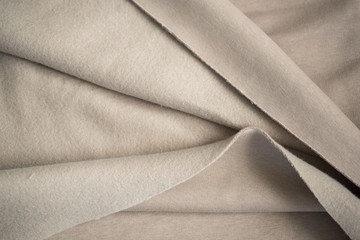 Soft towel fabric. Folds of cotton fabric. warm coat. Beautiful texture of beige and brown. A piece of fabric for a seamstress cut. The concept of warm cozy autumn