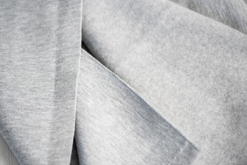 Waves on tissue folds on a piece of tissue surface. Folds of cotton fabric. warm coat. Beautiful texture of gray. A piece of fabric for a seamstress cut. The concept of warm cozy autumn