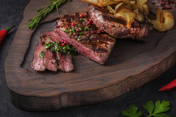 Tenderloin beef steak on wooden board, close view
