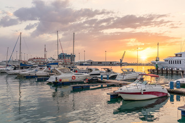 Yellow sunset in the sea harbor with moored yachts.