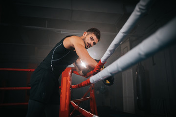 Closeup to the camera in a boxing ring great looking guy get ready for a boxing class intense workout