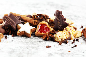 christmas cookies with spieses, nuts and fruits on rustic table